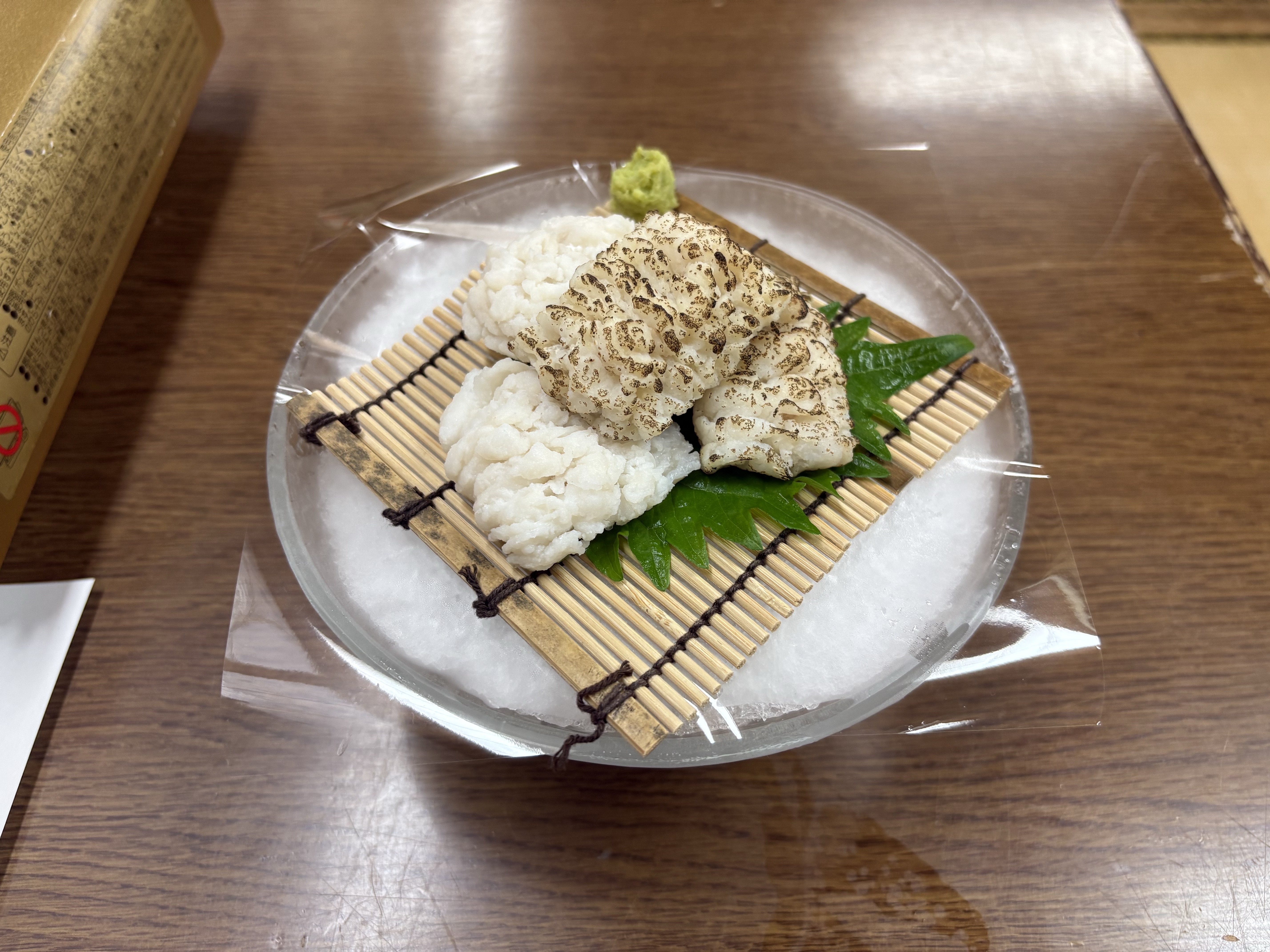 丸い皿に笹の葉を敷き、はもの落とし身を白く盛った、清潔感ある一皿